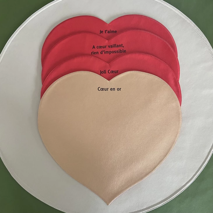 Faux leather place mat with a red or gold heart and a message to get your day off to a good start.