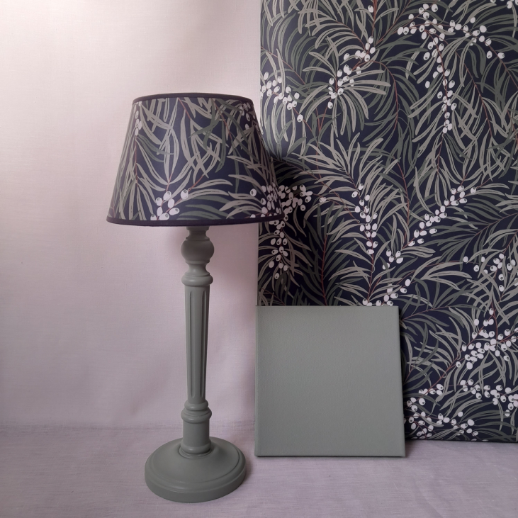 A fennel-green lamp with a shade made from Sandberg's IDUN Classic Blue wallpaper.