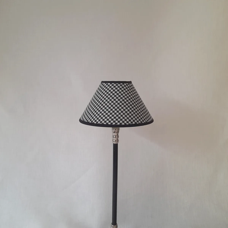 Small conical shade with white and black houndstooth pattern to clip onto the flame or ball bulb