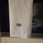 White linen tea towel embroidered with a ducal crown